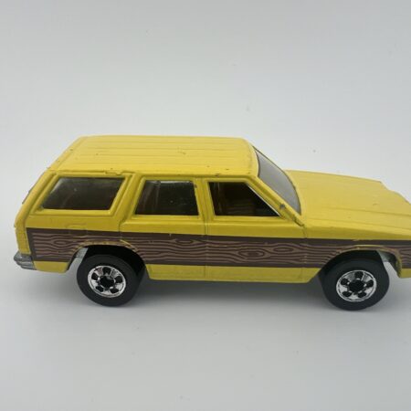 yellow station wagon diecast car with wood panel sides side view left profile vintage toy